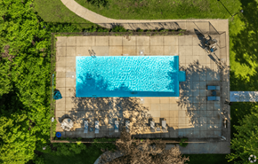 Madison apartment for rent - An aerial view of a rectangular swimming pool surrounded by a concrete patio and a grassy area.