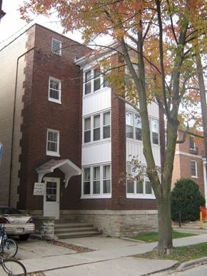 Madison apartment for rent - A tree with orange leaves stands in front of a red brick building.