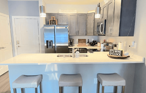 Wisconsin Dells apartment for rent - A kitchen with a white countertop and bar stools.