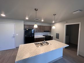 Eau Claire apartment for rent - a kitchen with a large island and a black refrigerator