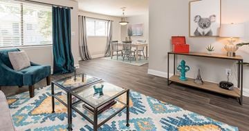 Richmond apartment for rent - A living room with a glass coffee table and a blue chair.