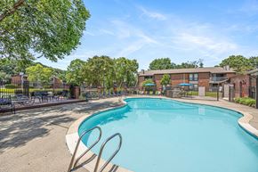 Newport News apartment for rent - A large swimming pool surrounded by trees and a fence.