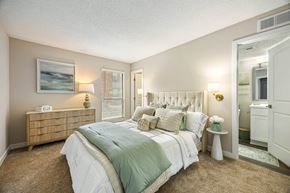 Newport News apartment for rent - A bedroom with a bed, nightstand, and a painting on the wall.