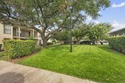 Temple apartment for rent - a yard with grass and trees in front of a building  at Parks on the Green, Temple, Texas