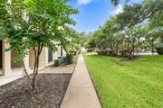 Temple apartment for rent - Walkway between buildings with mature trees and lawn at Parks on the Green Apartments, Temple, TX