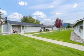 Kettle Falls apartment for rent - a group of white houses with a lawn and a sidewalk