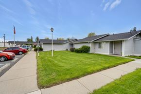 Deer Park apartment for rent - a white house with a lawn in front of a parking lot