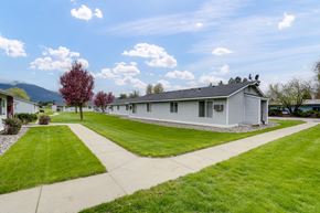 Kettle Falls apartment for rent - a white house with a lawn and a sidewalk