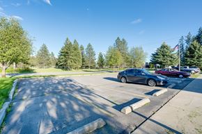 Rathdrum apartment for rent - a parking lot with cars parked in it and trees in the background