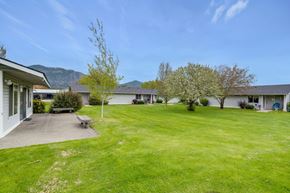 Chewelah apartment for rent - the backyard of a house with a green lawn and trees