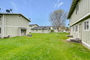 Chewelah apartment for rent - a row of houses with a green lawn and a blue sky