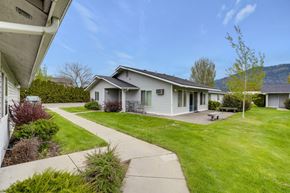Chewelah apartment for rent - a white house with a yard and a sidewalk