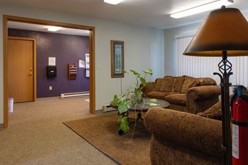 Joseph apartment for rent - A living room with a brown couch and a fire extinguisher.