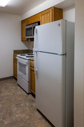 Joseph apartment for rent - A white refrigerator stands in a kitchen with a microwave and stove.