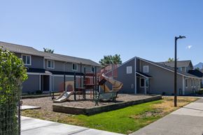 Joseph apartment for rent - A playground with a slide and swings in front of a row of houses.