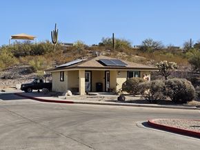Kearny apartment for rent - A house with a solar panel on the roof is surrounded by a desert landscape.
