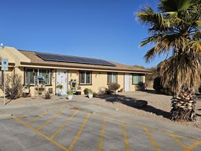 Kearny apartment for rent - A building with solar panels on the roof and a palm tree in front.