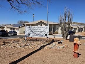 Tombstone apartment for rent - A sign for Desert Sage Apartments in Tombstone stands in front of a building.