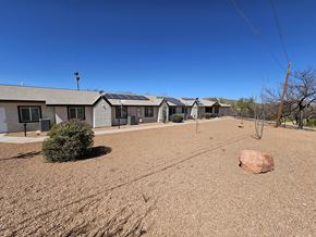 Tombstone apartment for rent - A large rock sits in the middle of a dirt field.