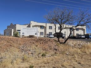 Huachuca City apartment for rent - A large building with a sign that says Desert Rose Apartments on it.