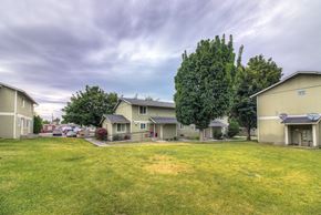 Warden apartment for rent - A grassy field with a few houses and trees in the background.