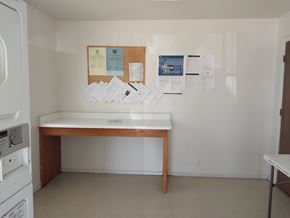 Eloy apartment for rent - A white wall with a bulletin board and papers on it.