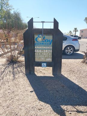 Eloy apartment for rent - A wooden sign for "Cay Village Apartments" stands in the desert.