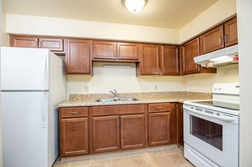 St.Helens apartment for rent - A kitchen with wooden cabinets and a white refrigerator.
