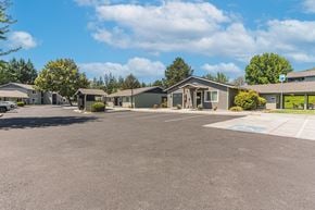 Grants Pass apartment for rent - an empty parking lot in front of a row of houses