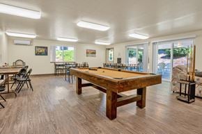 Grants Pass apartment for rent - a pool table in a community room with tables and chairs