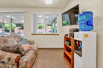 Grants Pass apartment for rent - a living room with a couch and a tv and a refrigerator