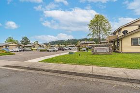 Sutherlin apartment for rent - a view of a neighborhood with houses and a sign on the grass