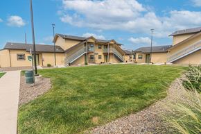 Phoenix apartment for rent - A grassy area in front of a building with a gravel path.
