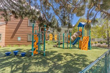 Bend apartment for rent - A playground with a slide, swings, and climbing structures.