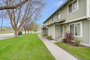 Chewelah apartment for rent - A tree with no leaves stands in front of a house.