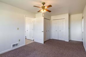 Island City apartment for rent - a bedroom with white walls and a ceiling fan