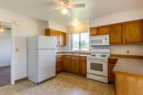 Island City apartment for rent - a kitchen with white appliances and wooden cabinets
