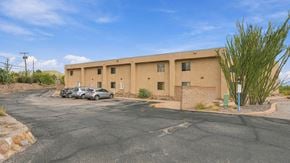 Bisbee apartment for rent - A parking lot with a building and a car.