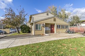 Newberg apartment for rent - the front of a house with a sidewalk and a bike parked outside