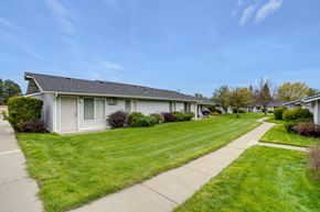 Deer Park apartment for rent - A row of houses with green lawns and a clear blue sky.