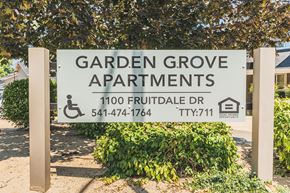 Grants Pass apartment for rent - a garden grove apartments sign in front of a tree