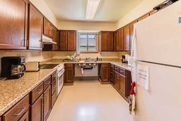 Grants Pass apartment for rent - a kitchen with wooden cabinets and granite counter tops and a refrigerator