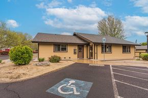 Talent apartment for rent - a handicapped accessible parking lot in front of a yellow building