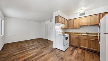 Bisbee apartment for rent - A kitchen with wooden cabinets and a white refrigerator.