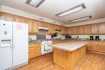 La Grande apartment for rent - A kitchen with wooden cabinets and a white fridge.