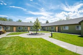 Wallowa apartment for rent - a group of green houses with a yard and sidewalk