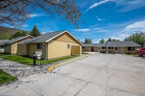 Wallowa apartment for rent - an empty parking lot in front of a yellow house