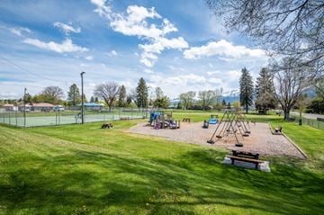 Enterprise apartment for rent - a playground with swings and a picnic table in a park