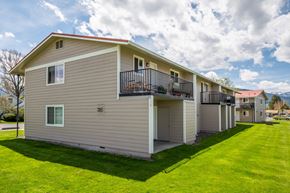 Enterprise apartment for rent - the view of an apartment building with a green lawn