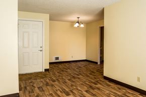 Redmond apartment for rent - an empty living room with a white door and wood flooring